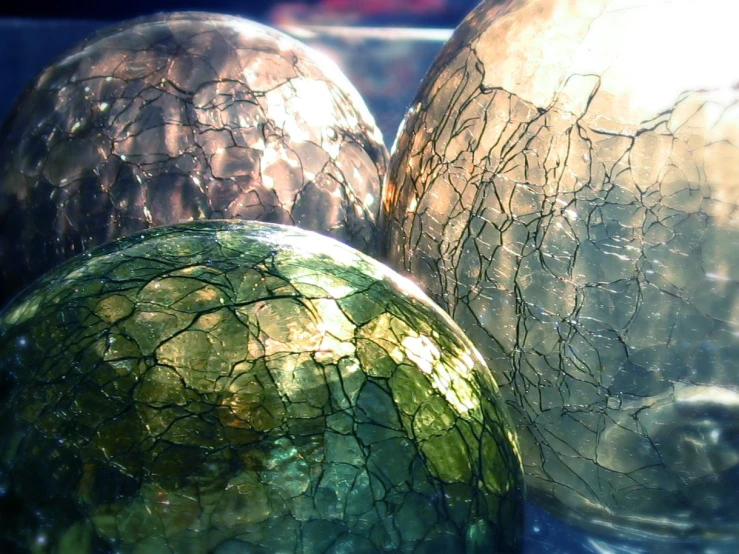 three decorative glass vases with some ed ones on them