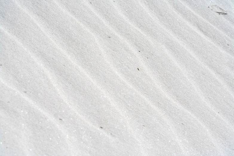 footprints on the beach sand and water on a sunny day