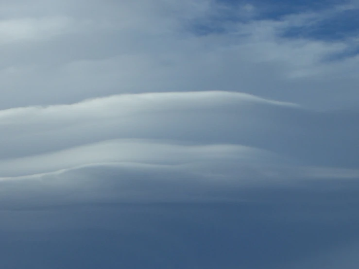 clouds with a plane flying in the distance