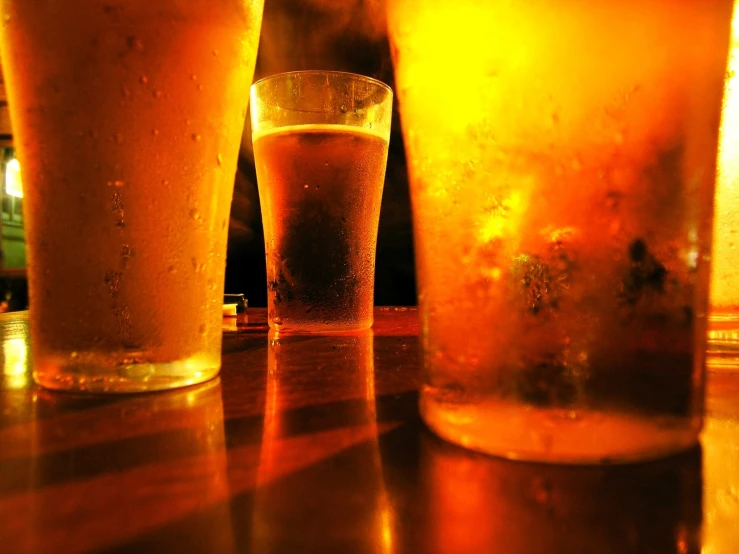 a row of glasses filled with beer sitting on a table