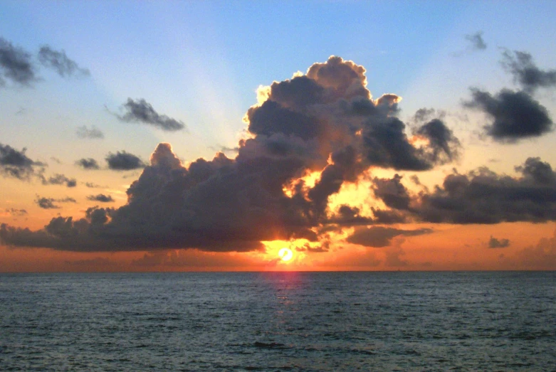 sun setting over the horizon on a cloudy day