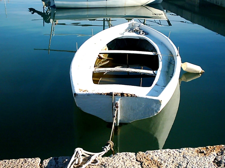 three boats are tied together at the water's edge