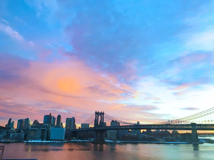 a sunset view of an urban bridge in the background