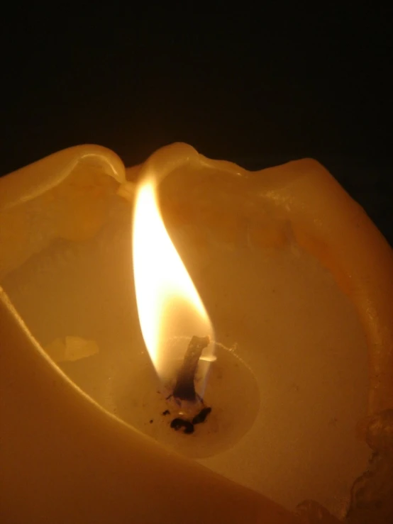 a candle lit up in the dark with a flame