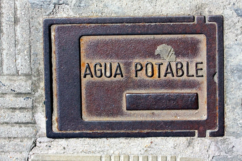 a grate is on the cement with the word aqua potable