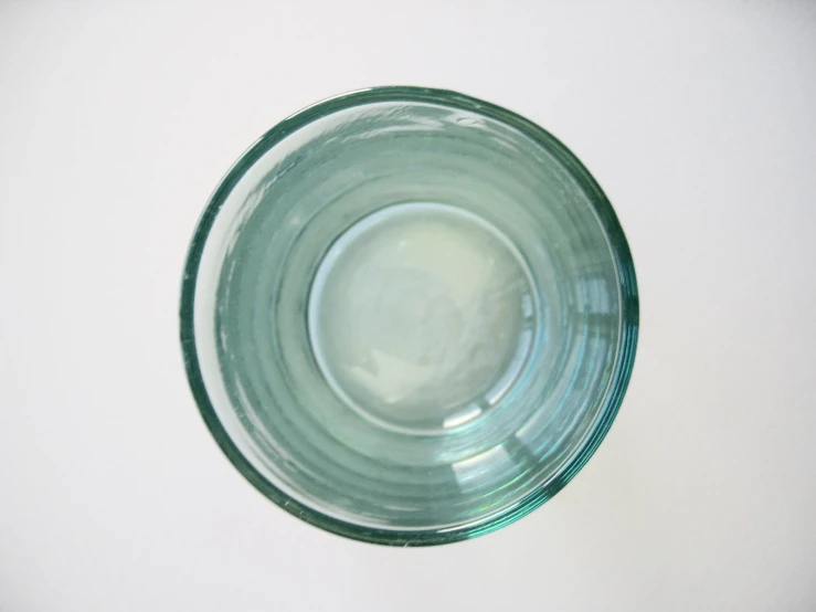 a green glass bowl is shown with small white circles