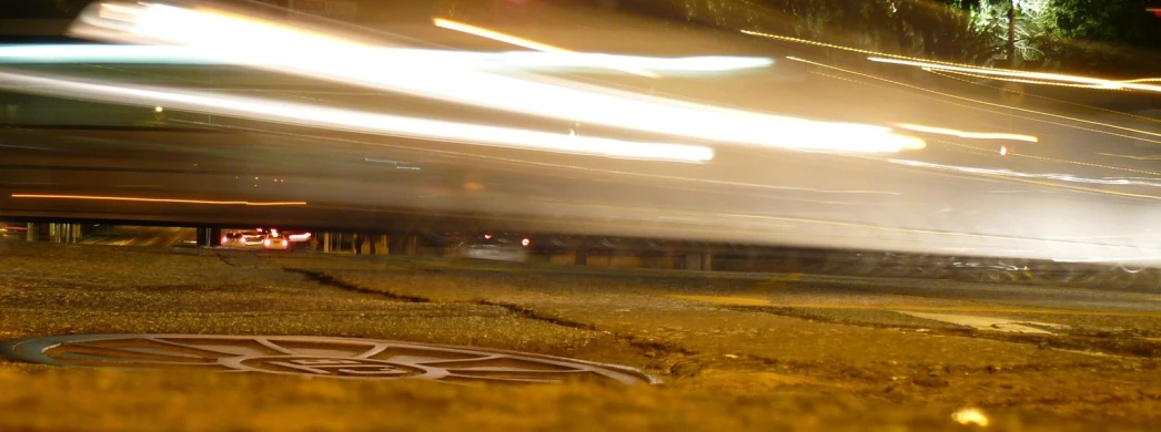 there is a road sign in the foreground and motion blur behind it