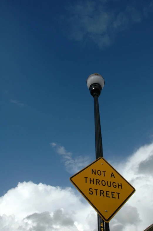 an upside down street sign attached to a light pole