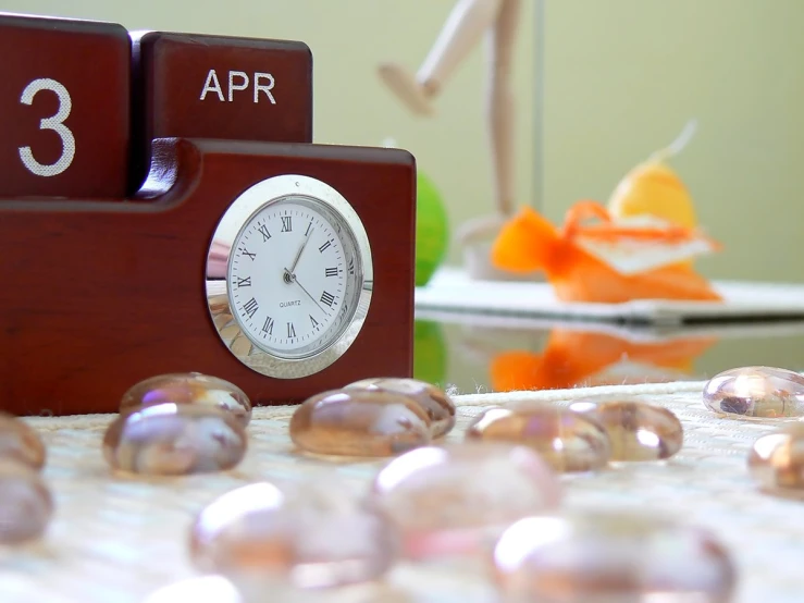 there is a wooden clock that reads 3 apr