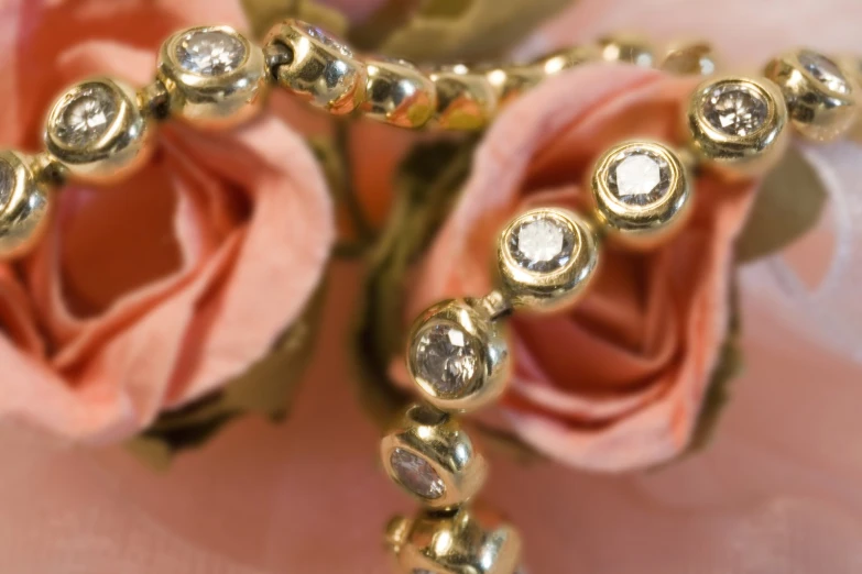 a rose bud with beadwork and crystals next to a rose