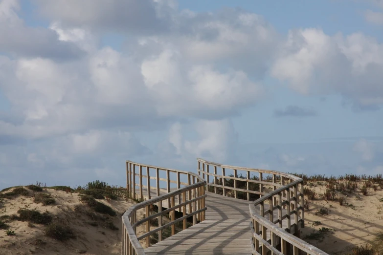 a pathway leads to an area that looks like sand dunes and beach