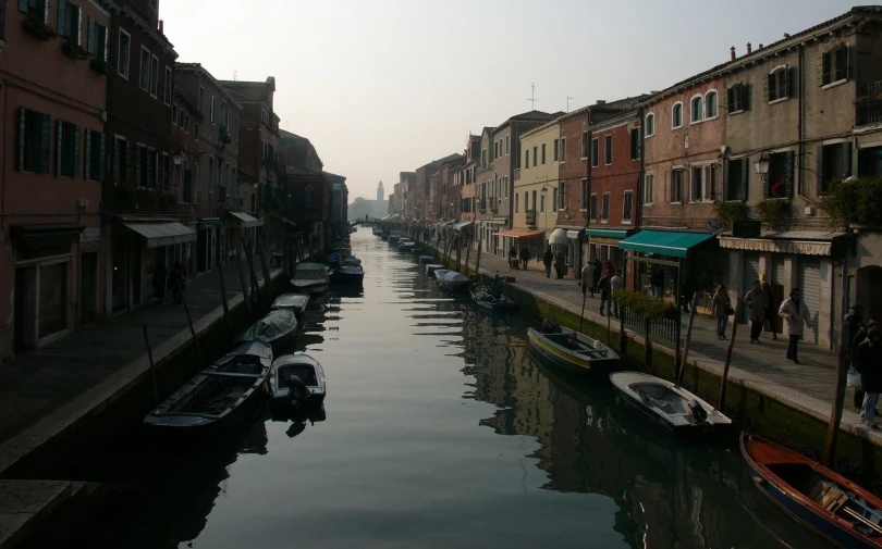 several boats are parked along a narrow canal