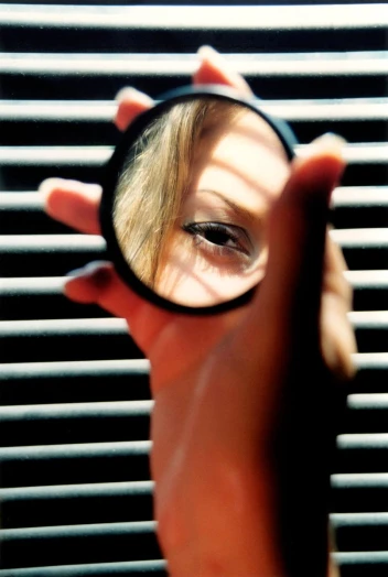a person holding up a magnifying glass in front of them
