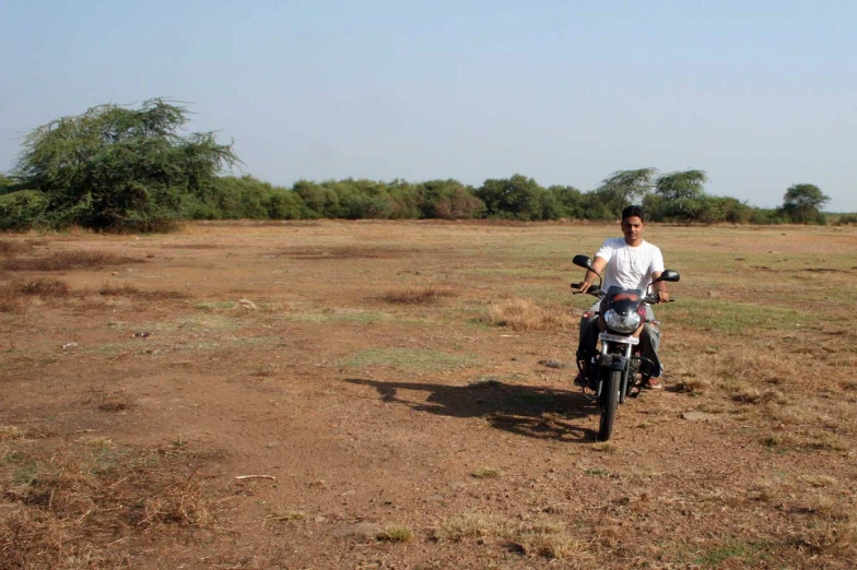 there is a man riding a motorcycle in the middle of nowhere