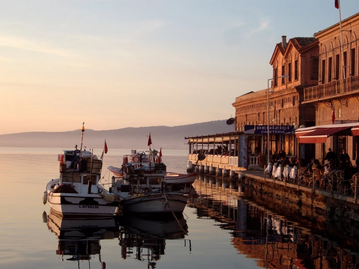 several boats parked in the water near a large building