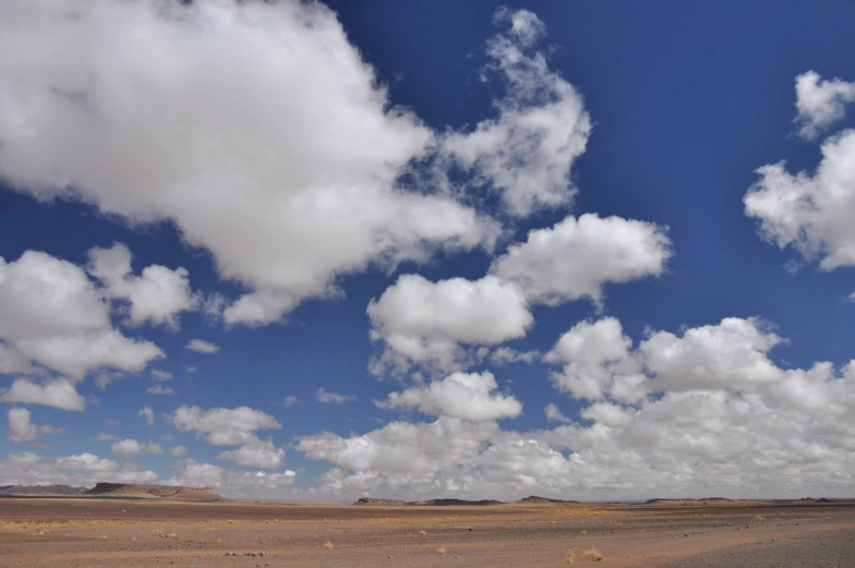 a large open field with many clouds above it