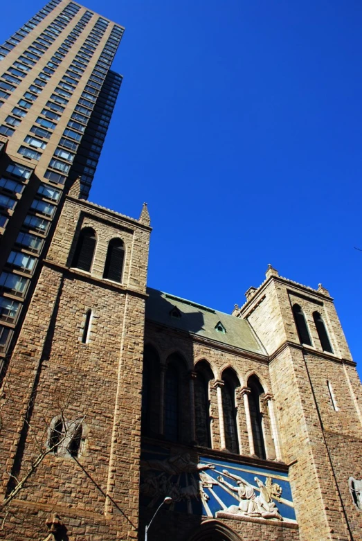 a large building with tall towers sitting next to a very tall skyscr