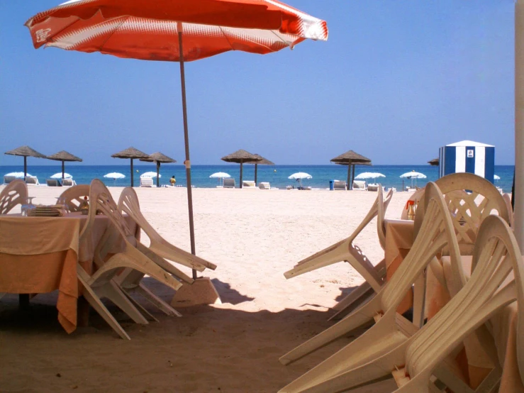 a line of chairs with a umbrella over them on the beach