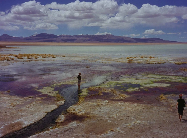 the two men are walking toward the mountains