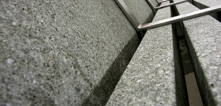 a metal bench on a sidewalk near a building