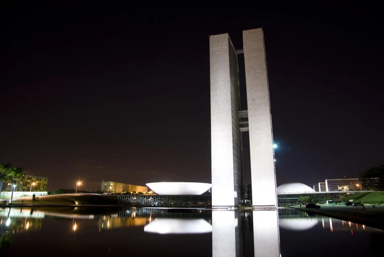 a view of some tall white towers in the dark