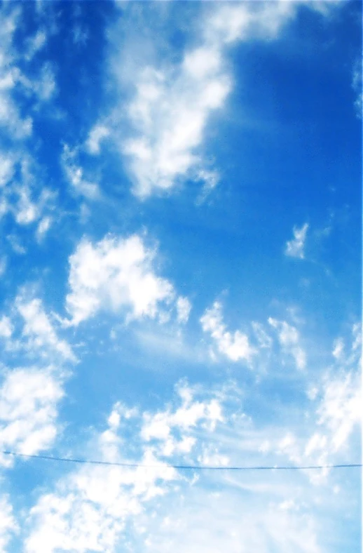 blue sky with clouds and two kites flying in the air