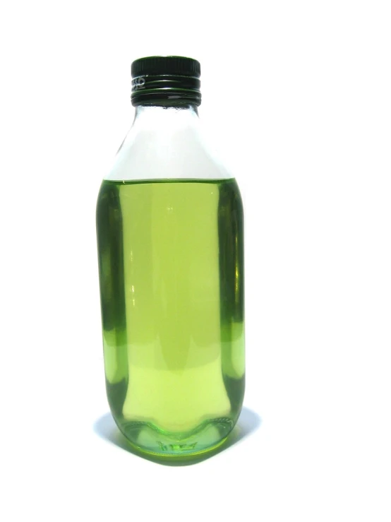 a glass bottle is full of liquid on a white surface