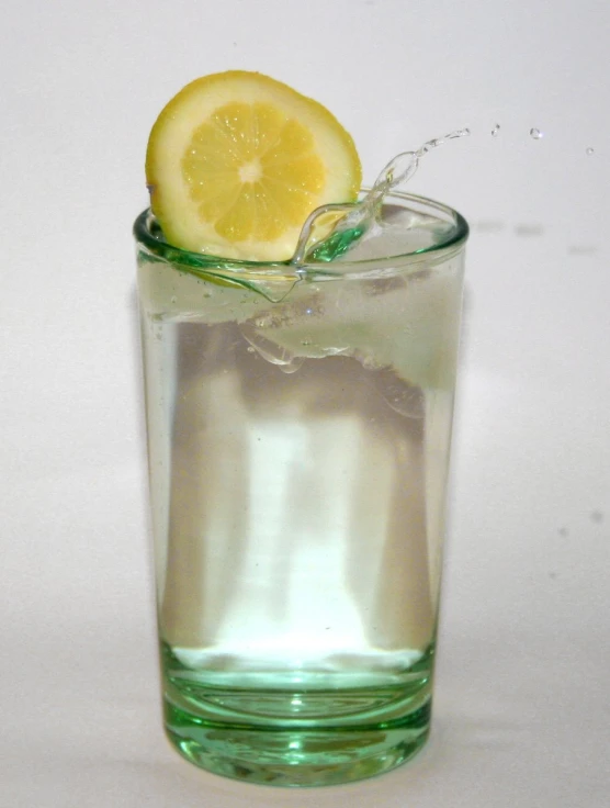 there is a glass of water with lemon slice