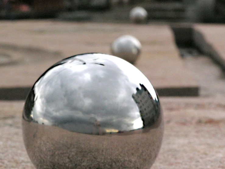 a sphere sculpture that has been placed on the ground