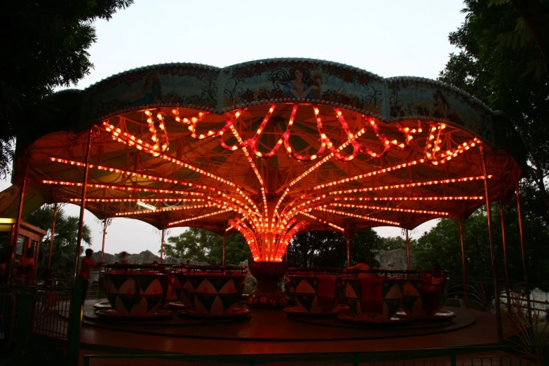 an ornate lighted carousel for children on a park