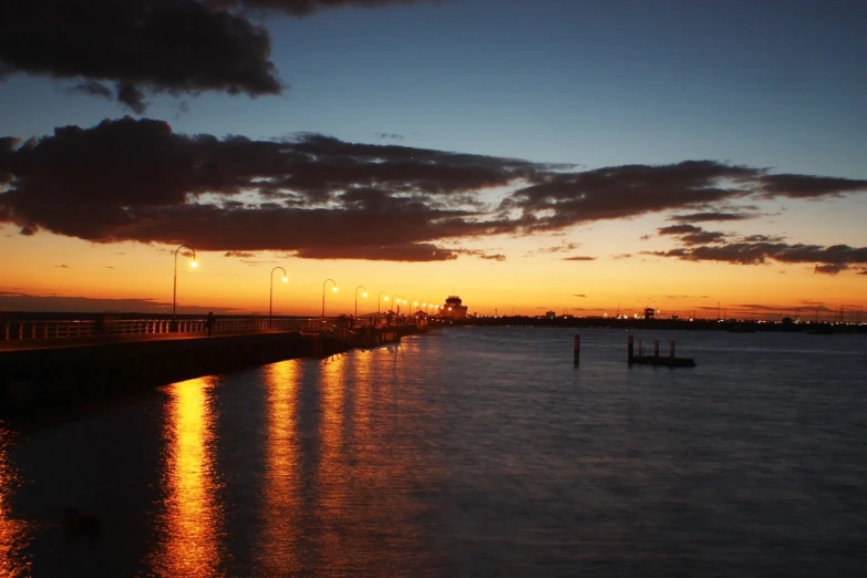 the sun sets over the river as the boats go down