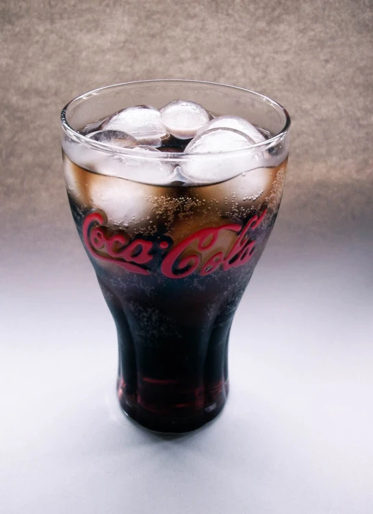 a coca cola glass filled with ice and soda balls