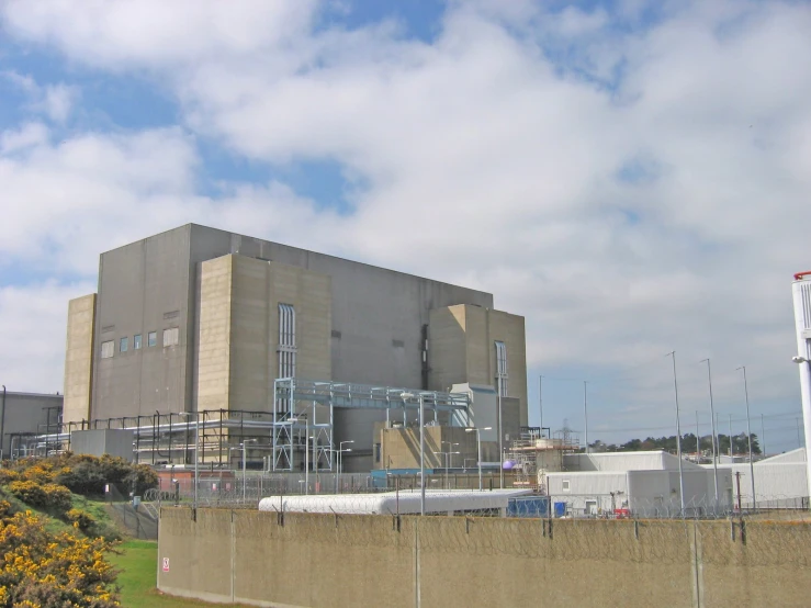 a large building near some buildings under a blue sky