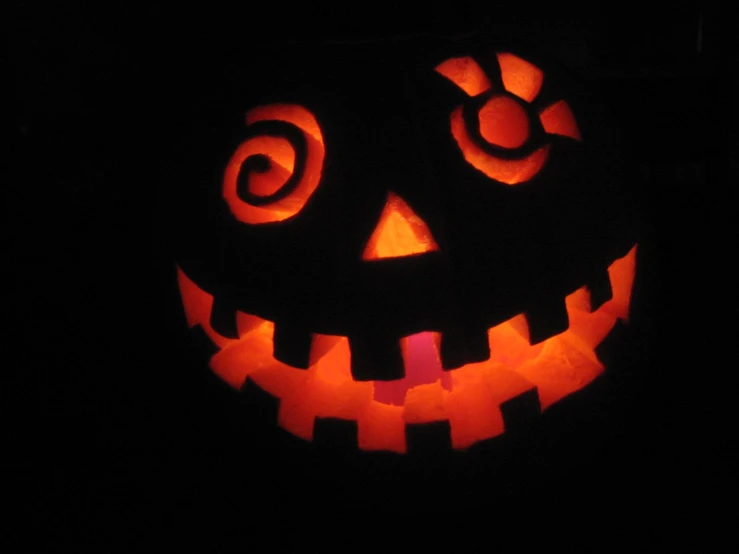 a pumpkin carved with many shapes and eyes