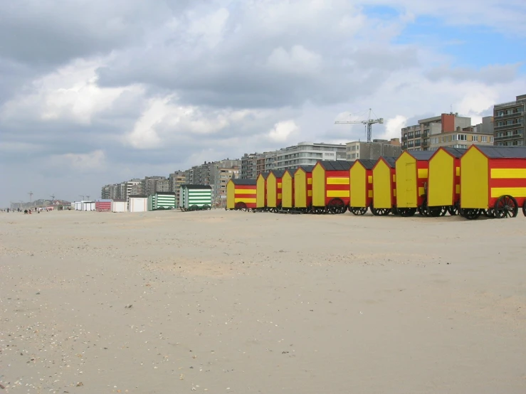 a row of brightly painted beach huts sitting in the sand