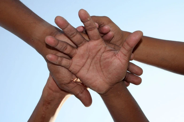 group of hands grabbing each other in the middle of their fingers