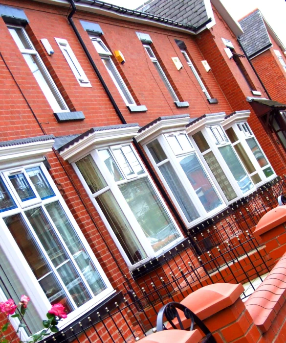 red fenced in area next to a row of orange brick buildings