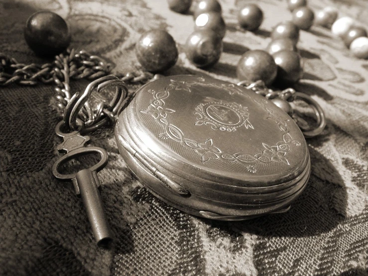 an antique pocket watch with a key on top of it