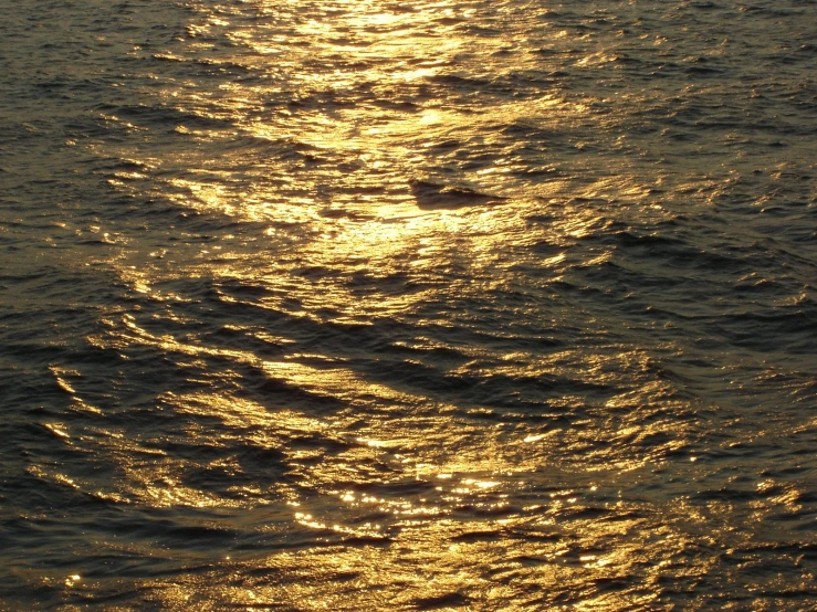 the sun shining in the ocean on a boat