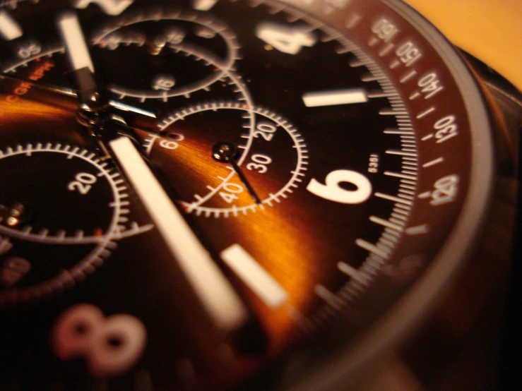 close up of brown wristwatch with the numbers two and three