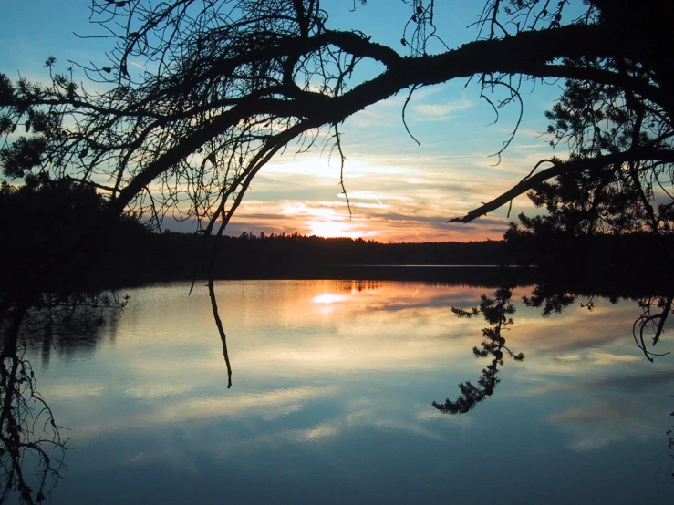 a beautiful view of the sky at dusk over a lake