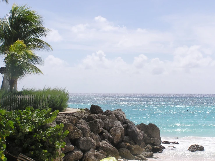 a rock formation in the foreground on a beach