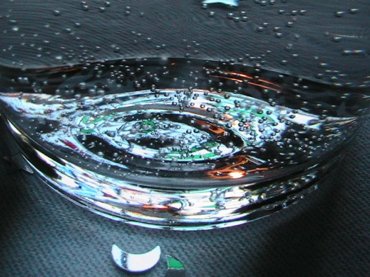 a glass bowl on the floor with water droplets