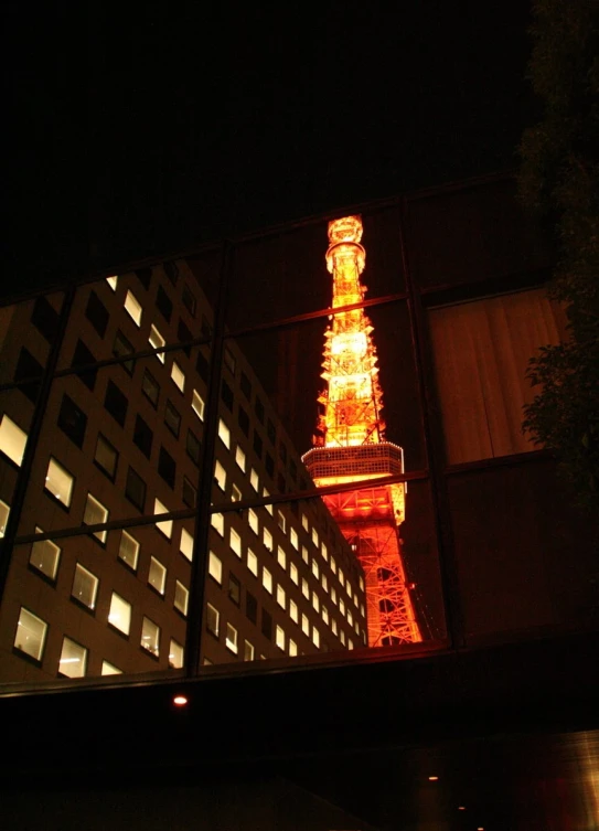 the eiffel tower is lit at night with orange colors