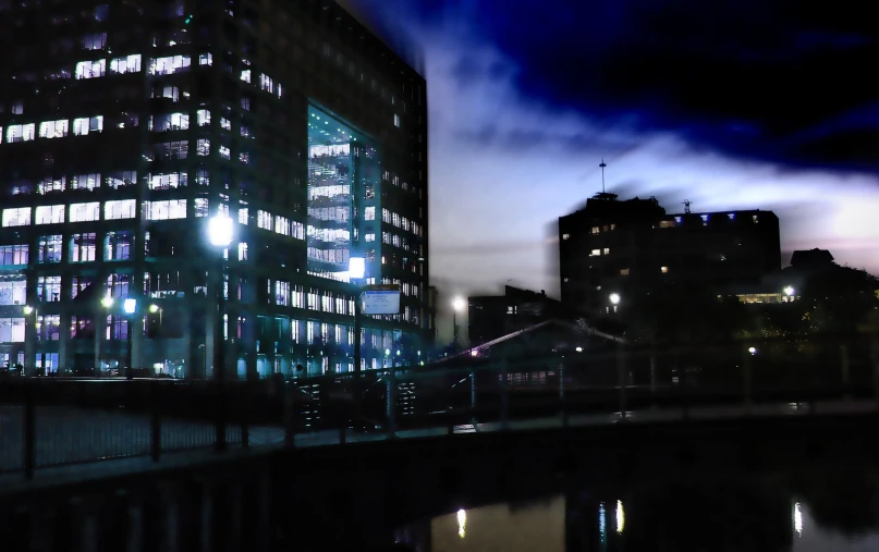 a night scene with a large building beside water