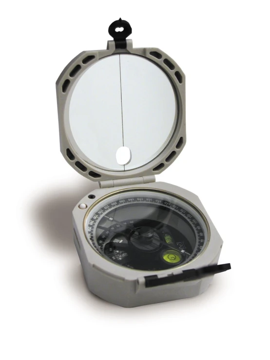 a compass sits on the ground with an open lid