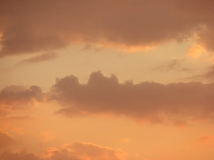 a jet is flying with clouds and sky in the background