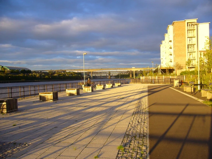 there is a walkway near the water near buildings