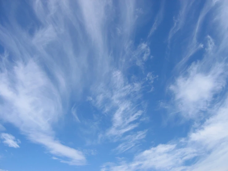 a lone red fire hydrant in the middle of a vast blue sky