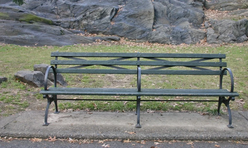 a empty park bench sitting in a park